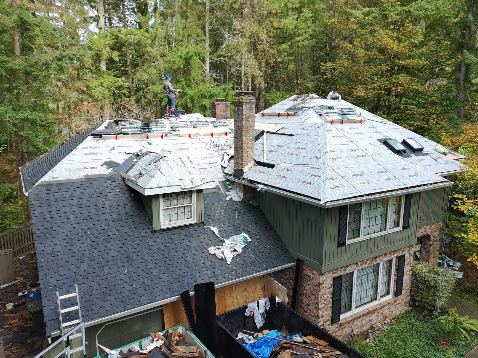 Roofing crew mid-installation on an aging roof replacement